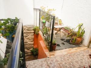 a balcony with potted plants and a table and a railing at Casa Patacalle in Ollantaytambo