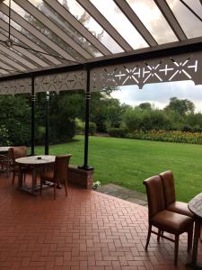 a patio with a table and chairs under a pergola at The oaklands hotel in Weaverham