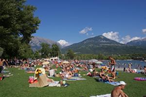 a crowd of people laying on the grass at a beach at les Jéhans in Chateauroux-les-Alpes