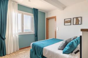 a bedroom with a bed with blue walls and a window at Sea Tower Torre Telemetrica Lido di Venezia in Venice-Lido