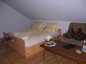 ein Schlafzimmer mit einem Bett, einem Sofa und einem Tisch in der Unterkunft Gästehaus Schneider in Bechtheim