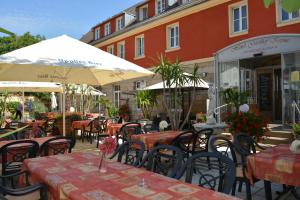 ein Restaurant im Freien mit Tischen, Stühlen und Sonnenschirmen in der Unterkunft Hotel-Gasthof Krone in Gunzenhausen