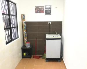 a kitchen with a stove and a sign on a wall at Pinggiran Homestay in Batu Caves