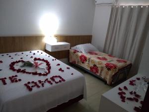 una habitación de hotel con 2 camas con rosas. en Aluguel Por Temporada Jcl, en Gramado