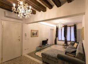un soggiorno con divano e lampadario pendente di Ca' Nal Apartments a Venezia
