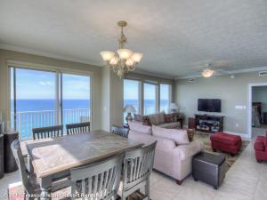 a living room with a table and a view of the ocean at Treasure Island 1601 in Panama City Beach