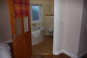 a bathroom with a bath tub and a toilet at The Anvil Lodge in Shifnal