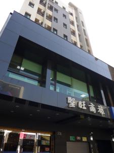 a building in front of a tall building at San Juan Easy Stay Inn Tainan in Tainan