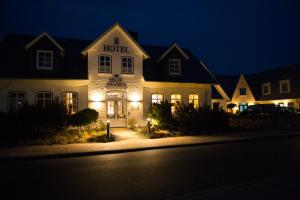 een hotel 's nachts met lichten voor de deur bij Hotel Hof Galerie in Morsum