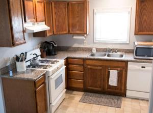 a kitchen with wooden cabinets and a white stove top oven at West End Neighborhood Cottage in Santa Rosa
