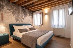 a bedroom with a bed and two windows at La Finestra sulle Beccarie in Venice