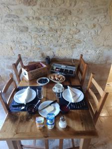 a wooden table with plates of food on it at L'étable gourmande chambres d'hôtes et ferme auberge in Aubas