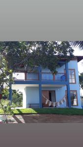 una casa blu e bianca con un albero di Vivendas da Serra Chalés a Martins