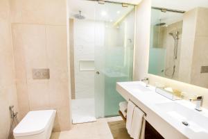 a bathroom with a sink and a shower and a toilet at Coral Level at Iberostar Selection Bavaro - All Inclusive in Punta Cana