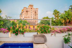 einen Balkon mit Blumen und einer Bank auf einem Gebäude in der Unterkunft Hotel Boutique Santo Toribio in Cartagena de Indias