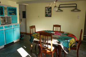 a kitchen with a table and chairs and blue cabinets at Gîte Chez Dimanche in Essert +4 photos