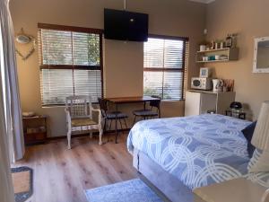 1 dormitorio con 1 cama, mesa y sillas en Big Bay Homestay, en Big Bay