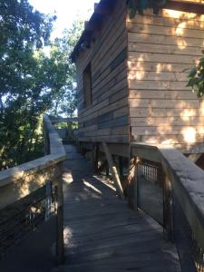 a wooden walkway next to a wooden building at Insolite Bois Cailloux avec Spa in Saint-Remèze