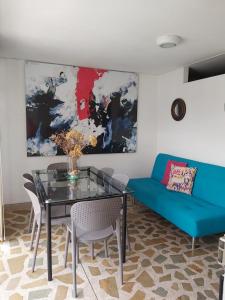 sala de estar con mesa de cristal y sofá azul en Apartamentos Amoblados JG de la 70, en Medellín