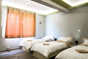 a bedroom with three beds and a window at Apartments "Our Place" Sarajevo in Ilidža