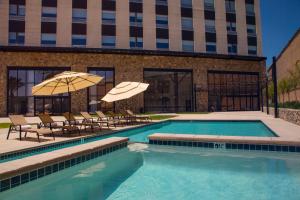 - une piscine avec des chaises et des parasols en face d'un bâtiment dans l'établissement Hotel Kumiai Inn, à Tecate