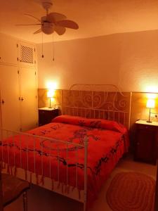 カレタ・デ・ベレスにあるApartamento Mi Casaのベッドルーム1室(赤いベッドカバー、ランプ2つ付)