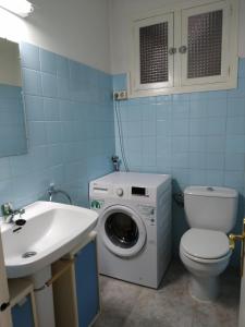 y baño con lavadora, aseo y lavamanos. en Casa cèntrica a La Bisbal d'Empordà en La Bisbal