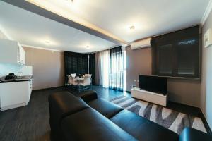 a living room with a couch and a kitchen at Apartments Prestige Petrcane 1 in Petrcane