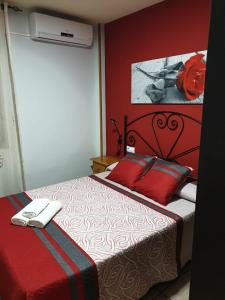 1 dormitorio con 1 cama con pared roja en Casa Eva, en Arroyo Frío