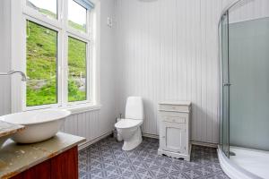 a bathroom with a toilet and a sink and a shower at Feriehus med flott havutsikt ved Hauklandstranden in Leknes