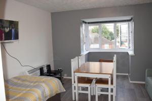 a bedroom with a desk and a bed and a window at 1 Bedroom Apartment Ponders End in London +16 photos