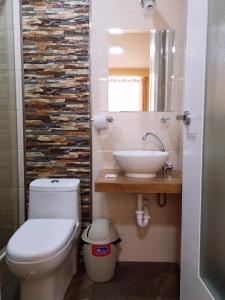 Un baño con un inodoro blanco y un lavabo. en Hostal D' Rosas, en Tacna