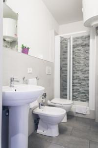 Un baño blanco con lavabo e inodoro. en Pisacentro Guest House, en Pisa