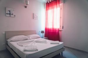 a bedroom with a bed with a red curtain at Pisacentro Guest House in Pisa