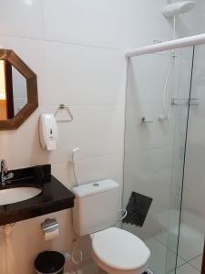 uma casa de banho com um WC e uma cabina de duche em vidro. em Hope Pousada em Arraial do Cabo
