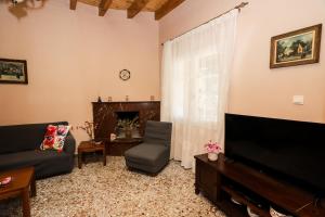 ein Wohnzimmer mit einem Sofa und einem TV in der Unterkunft Garden House Kastellani in Kastellánoi