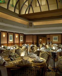 ein Esszimmer mit Tischen, Stühlen und Weingläsern in der Unterkunft Art Deco Imperial Hotel in Prag