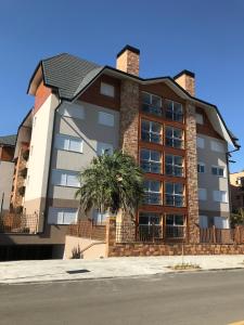 un edificio con una palmera delante en Apartamento Vêneto, en Canela