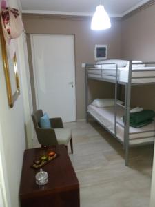 カラモスにあるKinetta Apartmentsの小さな客室で、二段ベッド2台、テーブルが備わります。