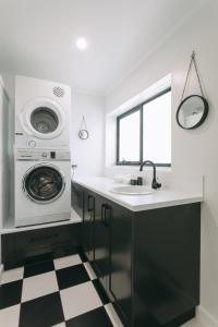 a kitchen with a washing machine and a sink at Deco Beach Luxury Apartments in Port Lincoln