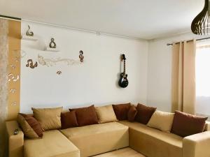 a living room with a couch and a guitar on the wall at Music Apartment in Otopenii de Jos