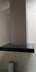 a microwave above a stove with a cup on a counter at Centrum Apartmán LEYLA 3 in Bardejov +39 photos