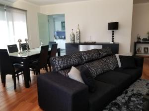 sala de estar con sofá negro y mesa en VIP Paradise Apartment, en Machico
