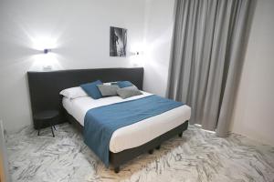 a bedroom with a large bed with a blue blanket at Mikeme in Carrara