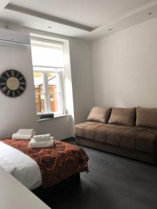 een woonkamer met een bank en een klok aan de muur bij Antwerp appartments in Sarajevo