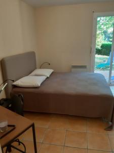 a bed sitting in a room with a window at Appartement dans propriété calme en pleine nature in Charbonnières-les-Bains
