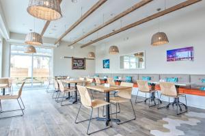 a dining room with tables and chairs and windows at Guy Harvey Resort on Saint Augustine Beach in Saint Augustine Beach