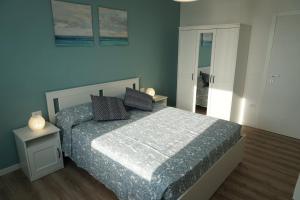 una camera con un letto con una parete blu di Appartamento Tramonto a Chioggia