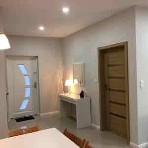 Habitación con escritorio, espejo y puerta. en Apartamenty Malwa, en Lądek-Zdrój