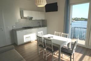 una cucina e una sala da pranzo con tavolo e sedie di Appartamento Tramonto a Chioggia